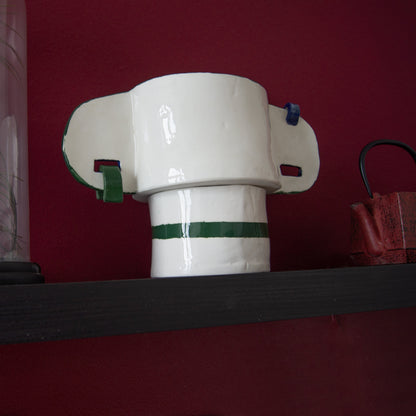 Green ceramic vase featuring ear-shaped handles with metal rings.