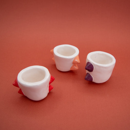 Three Bad Boys espresso cups with stud-like details in red, purple, and pink, each measuring 6 cm in height.