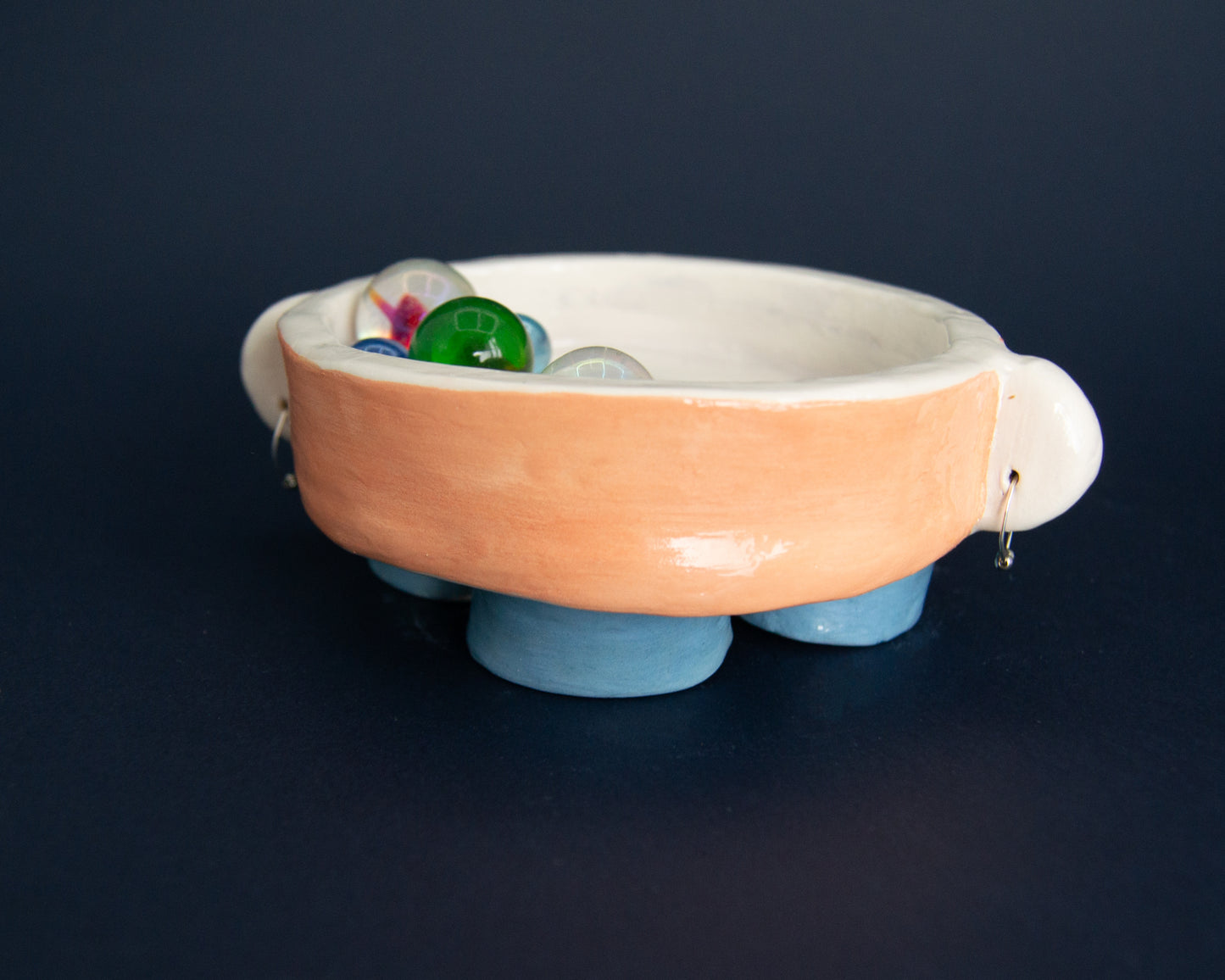 Listening valet bowl with feet, salmon and blue accents, perfect for holding earrings and small items.