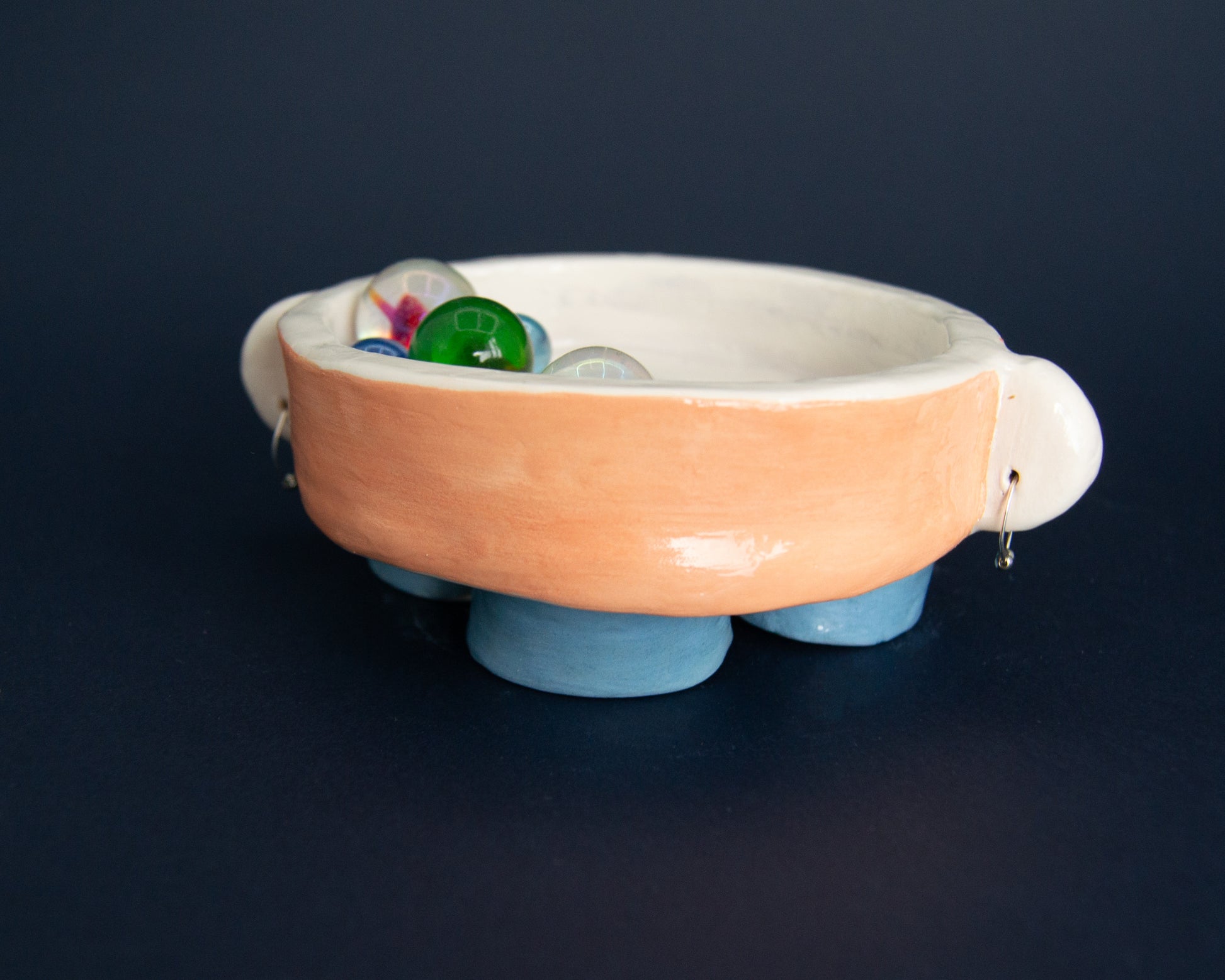 Listening valet bowl with feet, salmon and blue accents, perfect for holding earrings and small items.